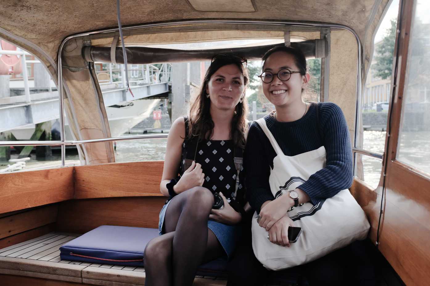 Two women riding in the back of a water taxi